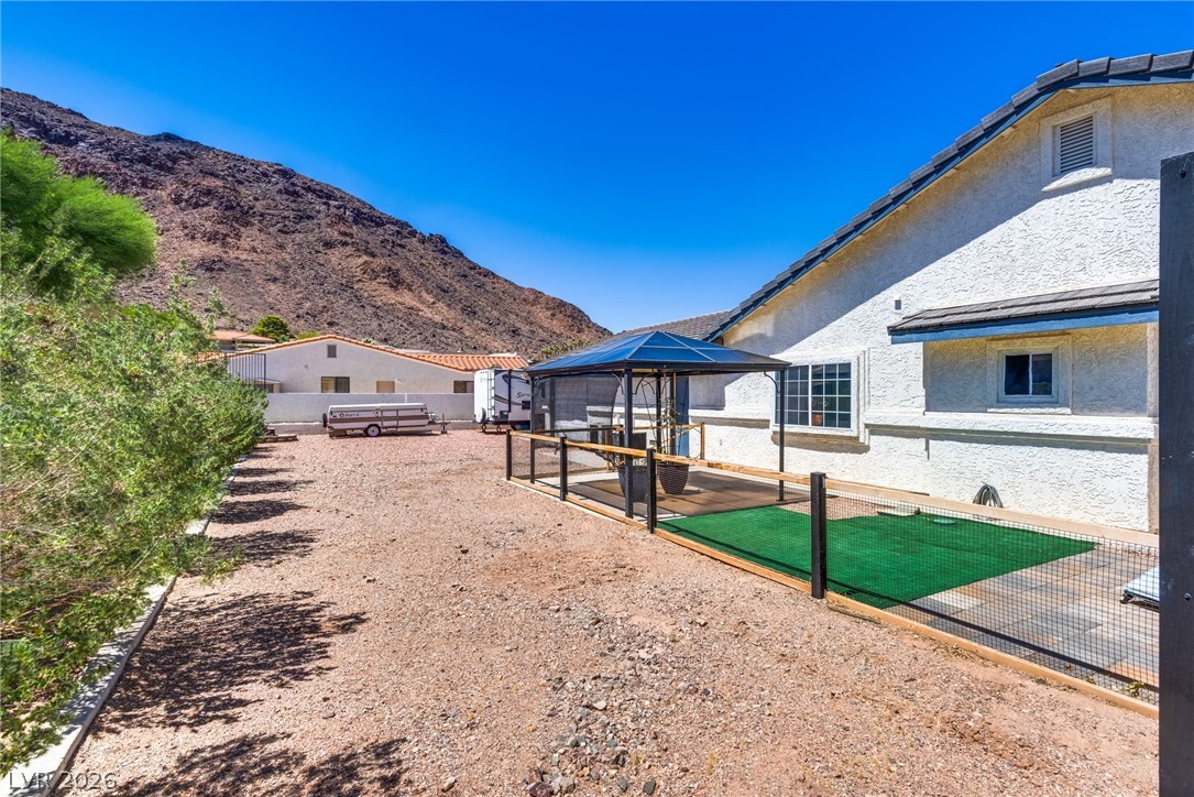 524 Swallow Cove Boulder City, NV 89005 - Photo 47 of 58 A spacious backyard with a mountain backdrop, featuring a covered patio for outdoor enjoyment.