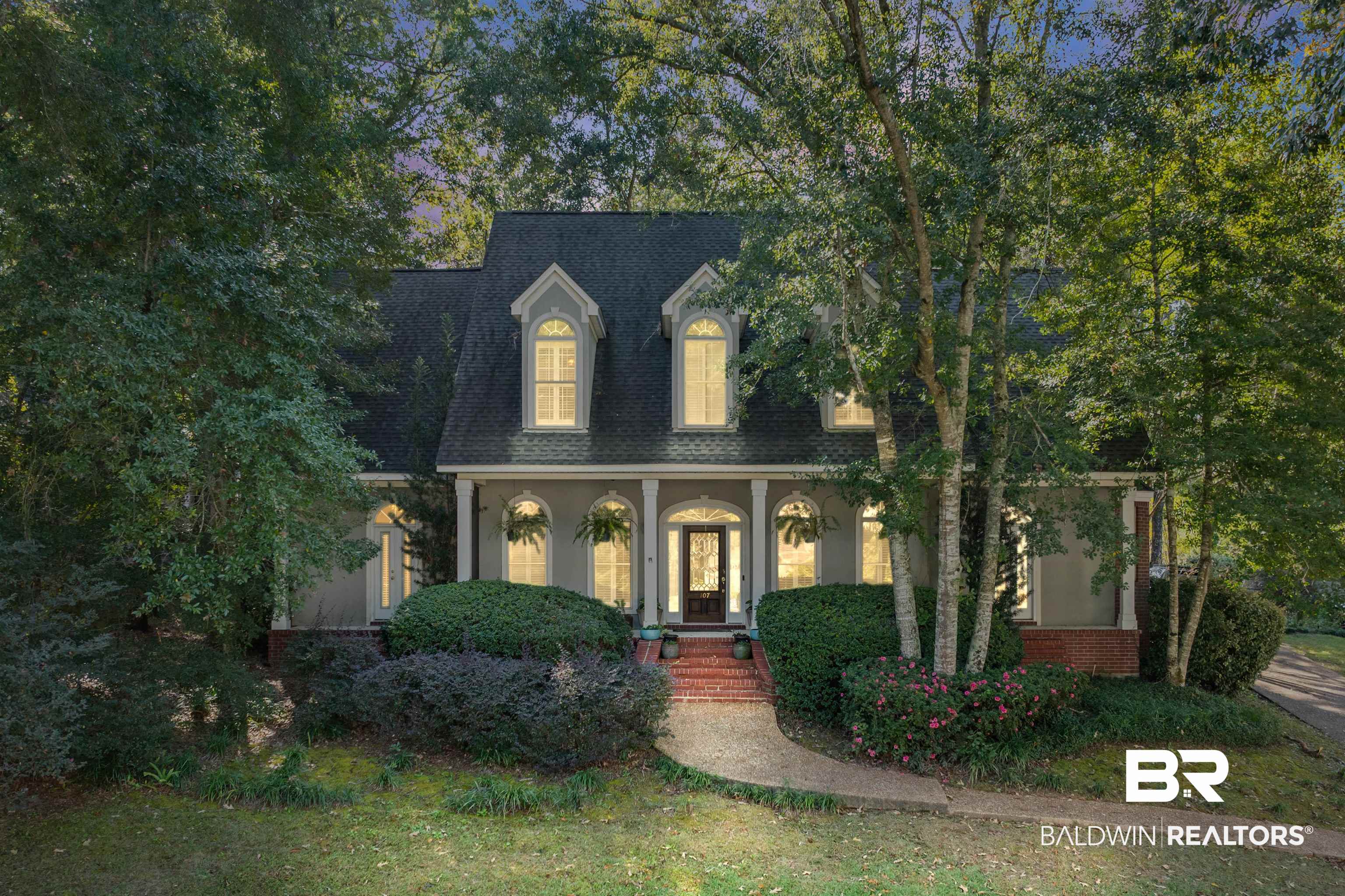 107 Beaver Dam Road Fairhope, AL 36532 - Photo 1 of 45 Cape cod-style house with a shingled roof, a porch, stucco siding, and a front yard