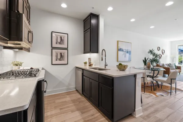 a kitchen that has a lot of cabinets in it and wooden floors