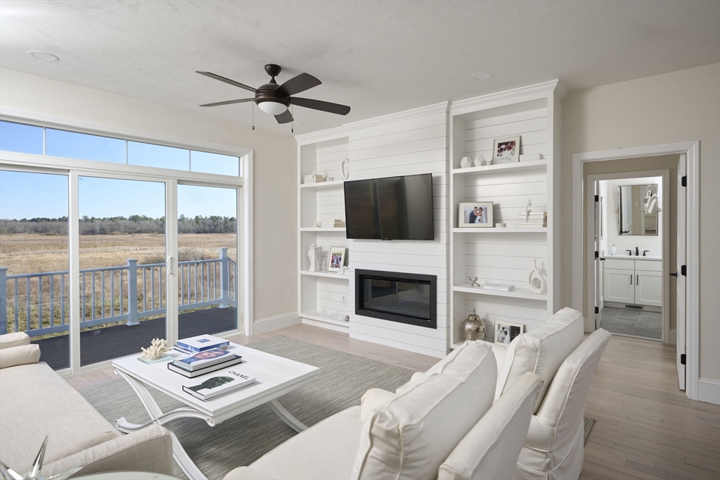 a living room with furniture a flat screen tv and a fireplace