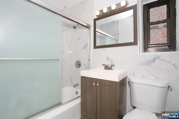 a bathroom with a sink a toilet and a mirror