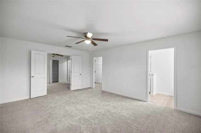 an empty room with a ceiling fan and a window