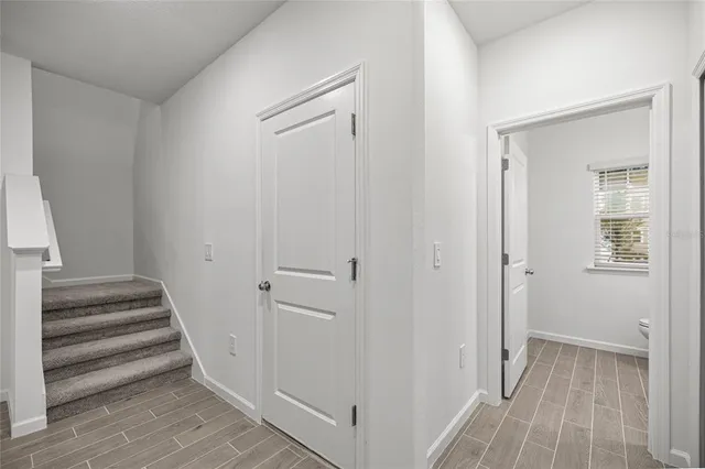 a view of a hallway with wooden floor and entryway