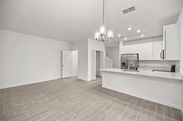 a large kitchen with kitchen island a sink stainless steel appliances and cabinets