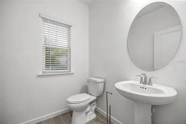 a bathroom with a sink a toilet and a mirror