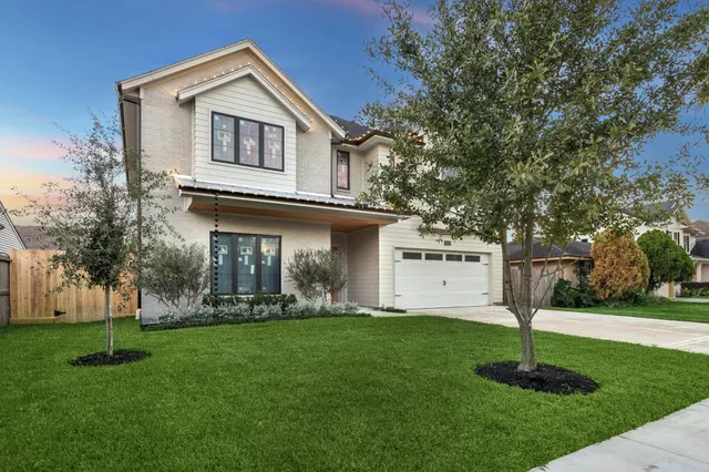 a front view of a house with a yard and trees