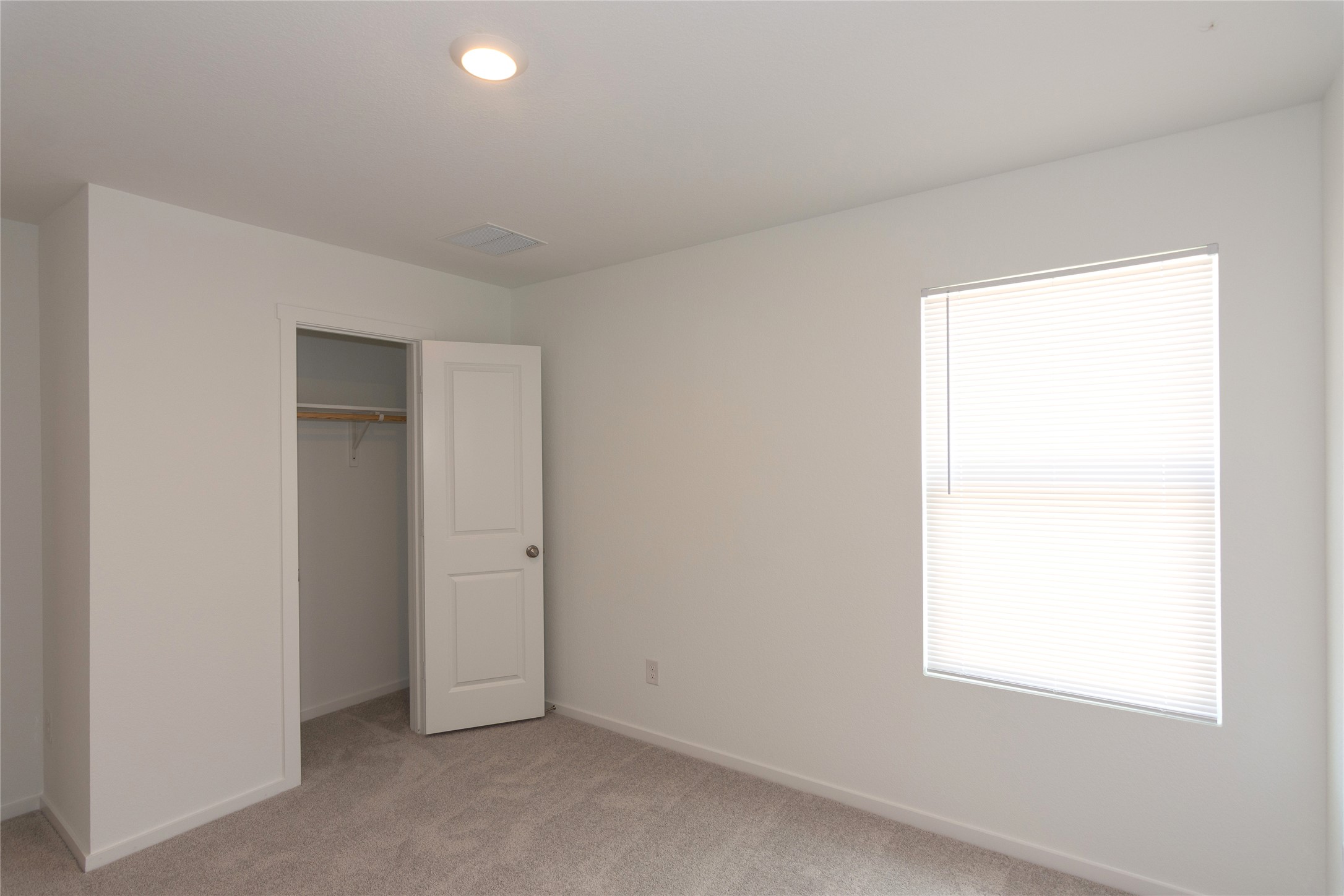 149 Star Packer Lane Jarrell, TX 76537 - Photo 18 of 30 A well-lit, neutral-toned bedroom provides a comfortable and adaptable personal space.
