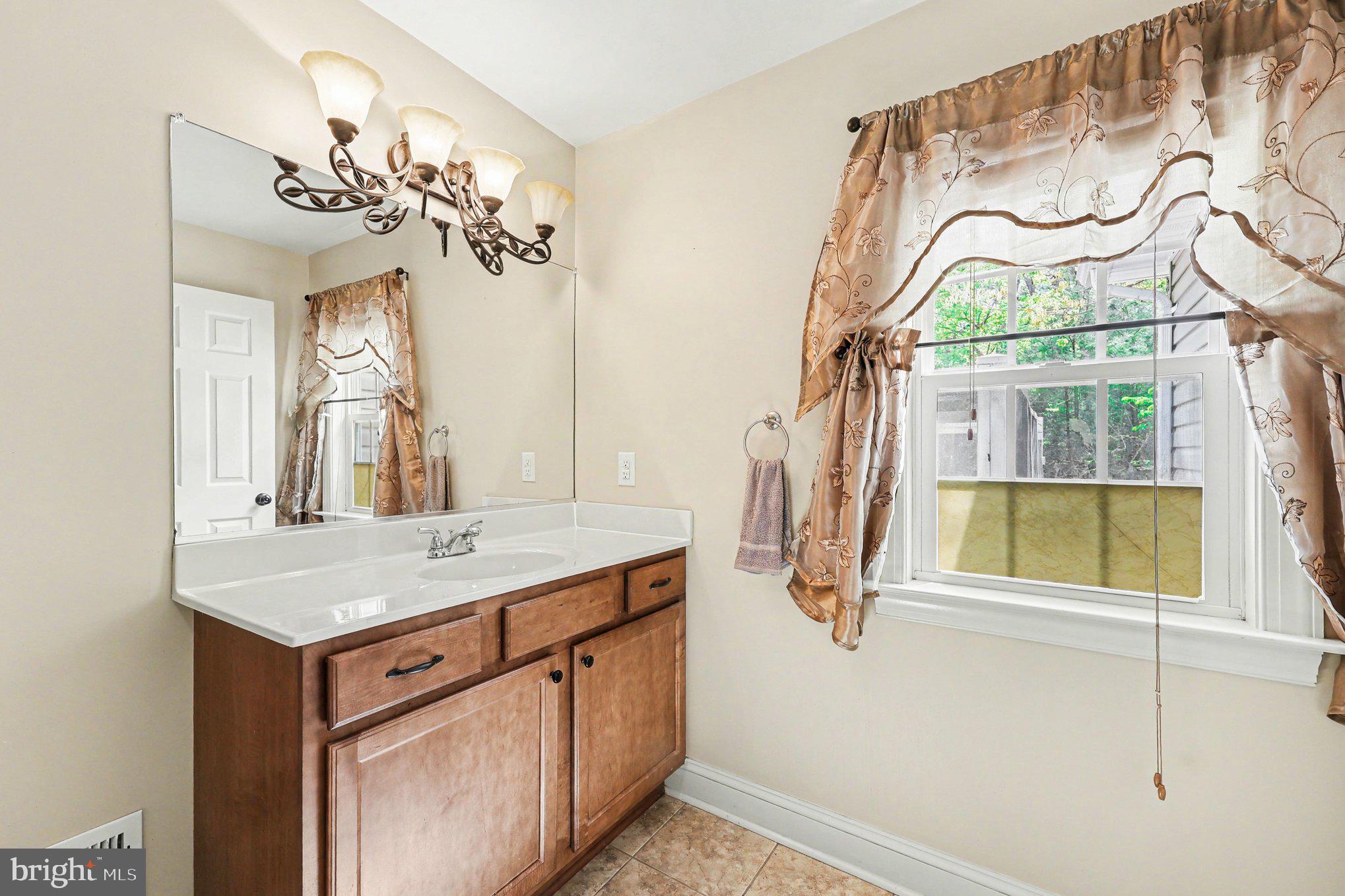 1564 Perry Road Winchester, VA 22602 - Photo 25 of 42 a bathroom with a granite countertop sink a mirror and a vanity