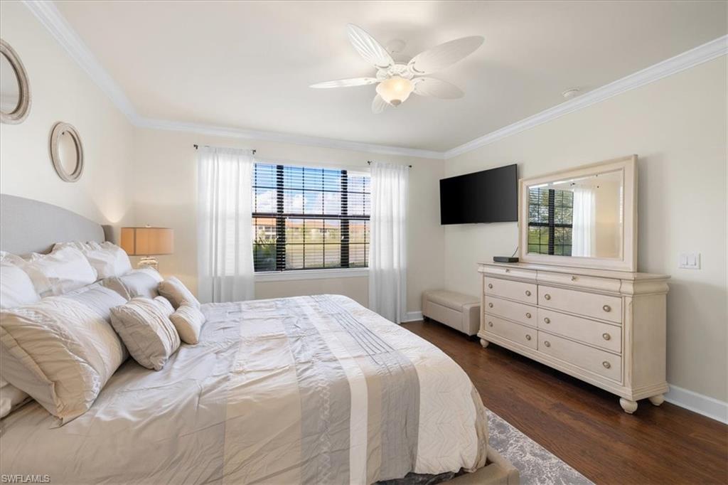 9684 Montelanico Loop, Unit 102 Naples, FL 34119 - Photo 15 of 24 a bedroom with a bed and a flat screen tv