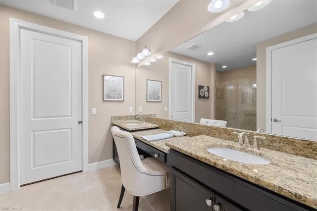 a bathroom with a granite countertop sink a mirror and a vanity