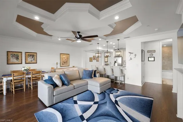 a living room with furniture a wooden floor and a chandelier