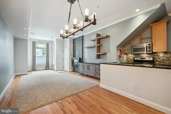 a large kitchen with stainless steel appliances granite countertop a refrigerator a oven a sink dishwasher and white cabinets with wooden floor