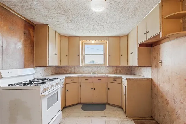 a kitchen with a stove sink and cabinets