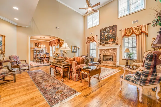 a living room with fireplace furniture and a large window
