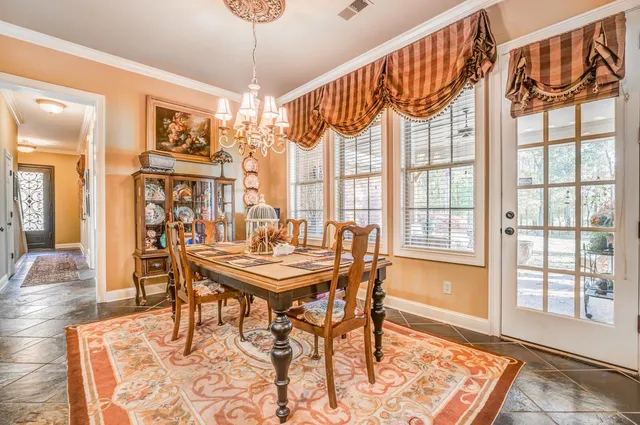 a view of a dining room and livingroom with furniture wooden floor a chandelier