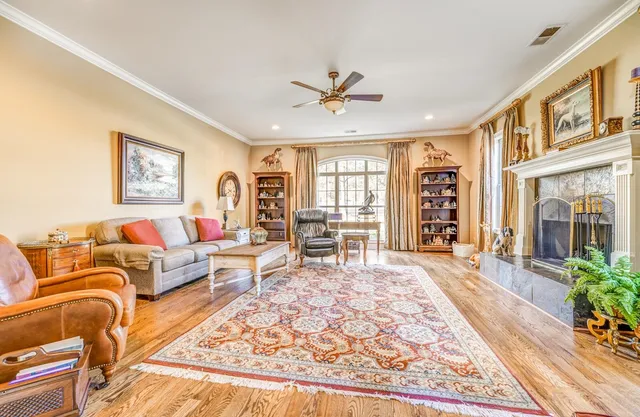 a living room with furniture large window and wooden floor