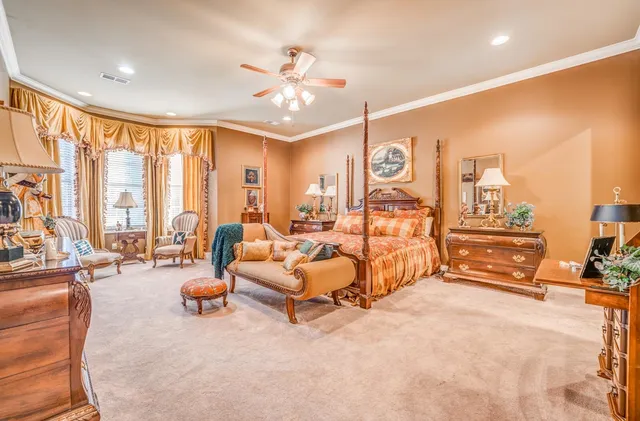 a bedroom with furniture and large windows
