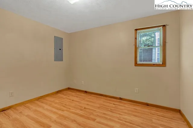an empty room with a window and a ceiling fan