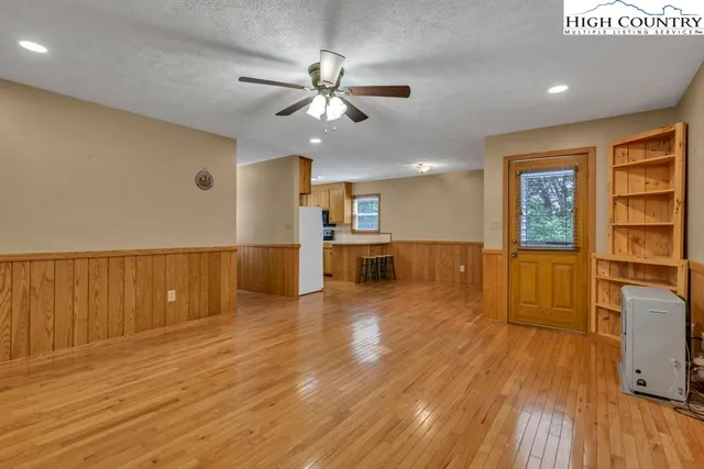 a view of a kitchen with a sink cabinet a kitchen island wooden floor and a window