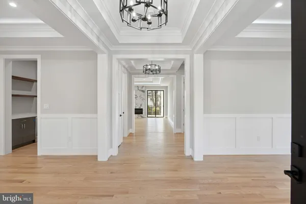a large white kitchen with kitchen island a sink stainless steel appliances and cabinets
