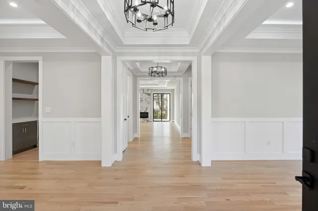 a large white kitchen with kitchen island a sink stainless steel appliances and cabinets
