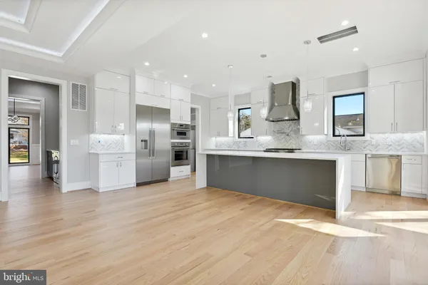 an empty room with kitchen and fireplace