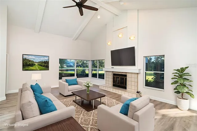 a living room with furniture fireplace and a large window