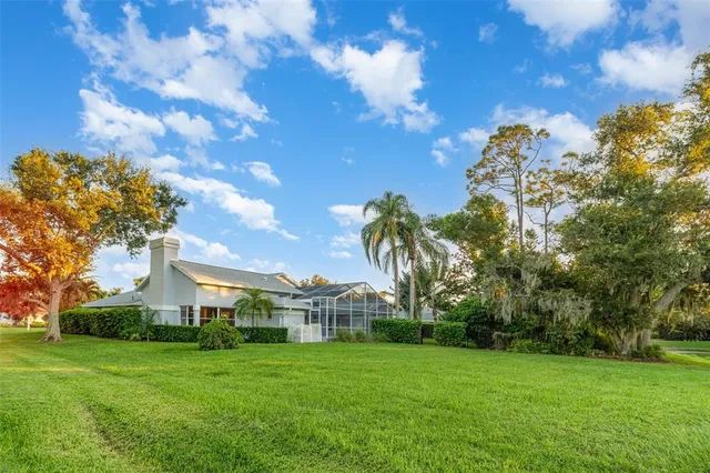 a view of a big house with a big yard and large trees