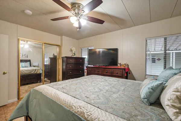 a bedroom with a bed and a mirror on the dresser