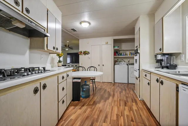 a very nice looking kitchen with a table chairs and a refrigerator