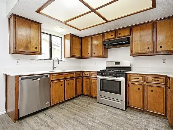 a kitchen with stainless steel appliances granite countertop a stove sink and cabinets