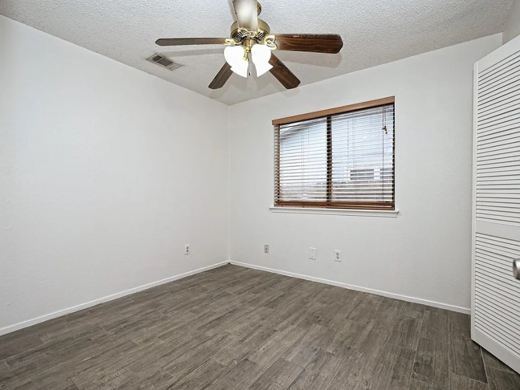 10406 Macmora Road Austin, TX 78758 - Photo 5 of 9 a view of an empty room with wooden floor and a window
