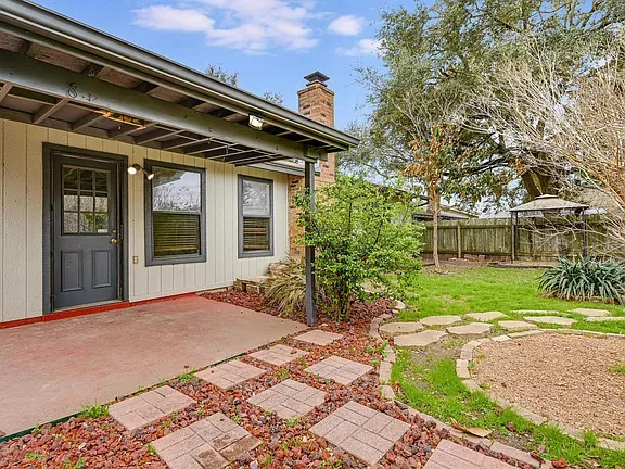a view of a house with a large window and yard