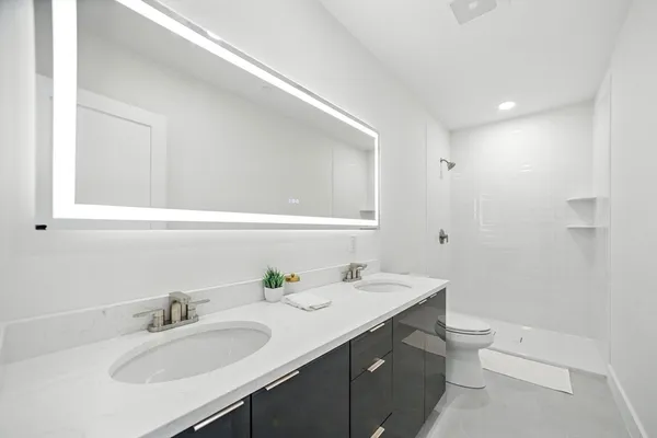 a bathroom with a sink a toilet and a mirror