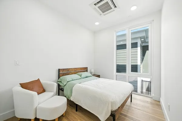 a bedroom with a bed and wooden floor