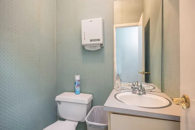 a bathroom with a toilet sink and mirror
