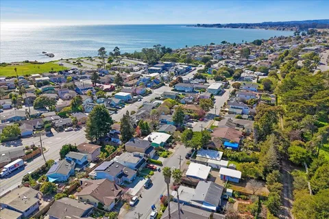 an aerial view of a city with lots of residential buildings and mountain view in back