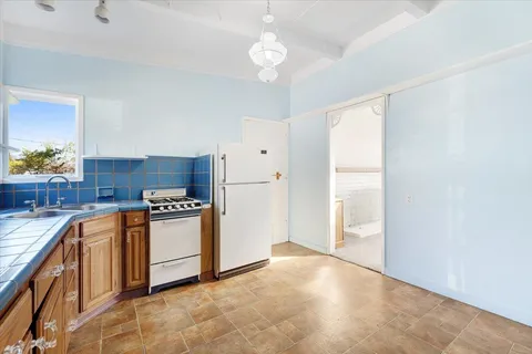 a kitchen with stainless steel appliances granite countertop a stove a refrigerator and a sink with granite countertops