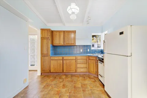 a kitchen with granite countertop stainless steel appliances a refrigerator a sink and a stove