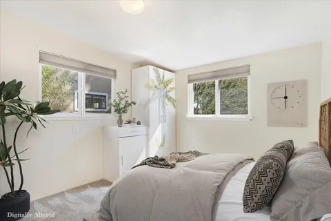 a bedroom with a bed and a large window with outer view