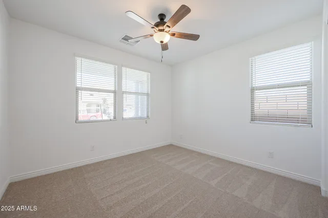 an empty room with a window and a fan