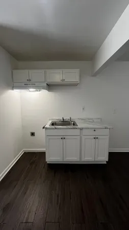 a view of a kitchen with cabinets and wooden floor