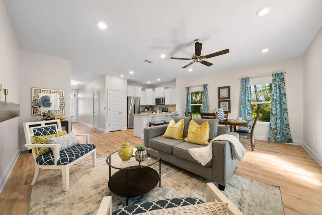 a living room with furniture kitchen view and a large window