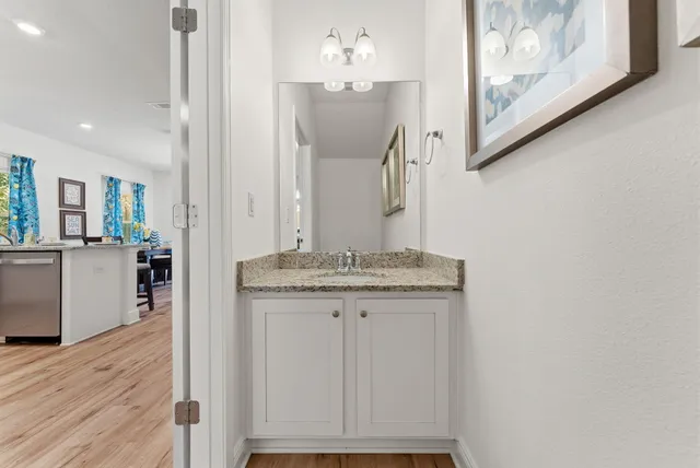 a bathroom with a granite countertop sink a mirror and a vanity