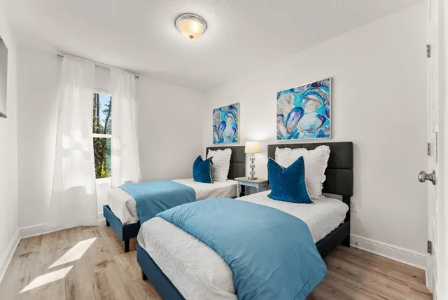 a bedroom with two beds and a window