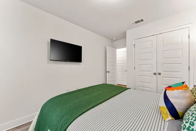 a bedroom with a bed and a flat screen tv