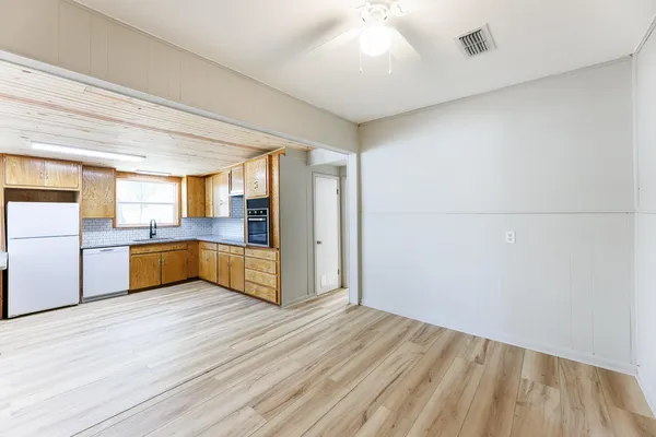a view of a livingroom with wooden floor and a ceiling fan