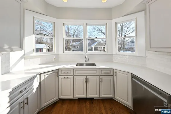 a kitchen with a sink cabinets and wooden floor