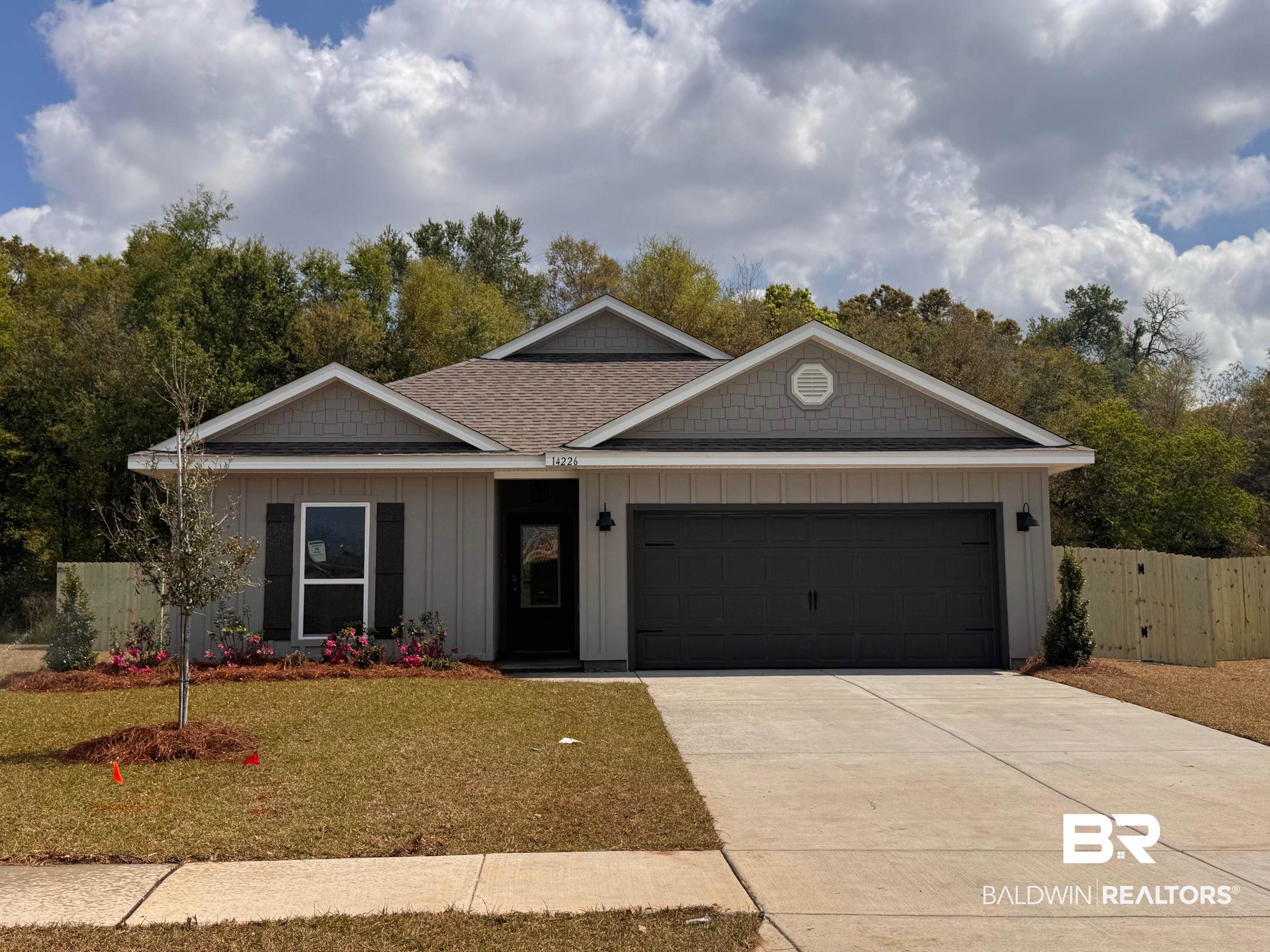 14226 Versailles Circle Silverhill, AL 36576 - Photo 1 of 37 View of front of home featuring board and batten siding, a garage, driveway, and roof with shingles
