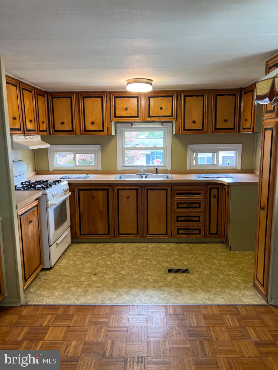 1302 Gibson Road, Unit 152 Bensalem, PA 19020 - Photo 1 of 18 a kitchen with stainless steel appliances granite countertop a stove a sink and a microwave